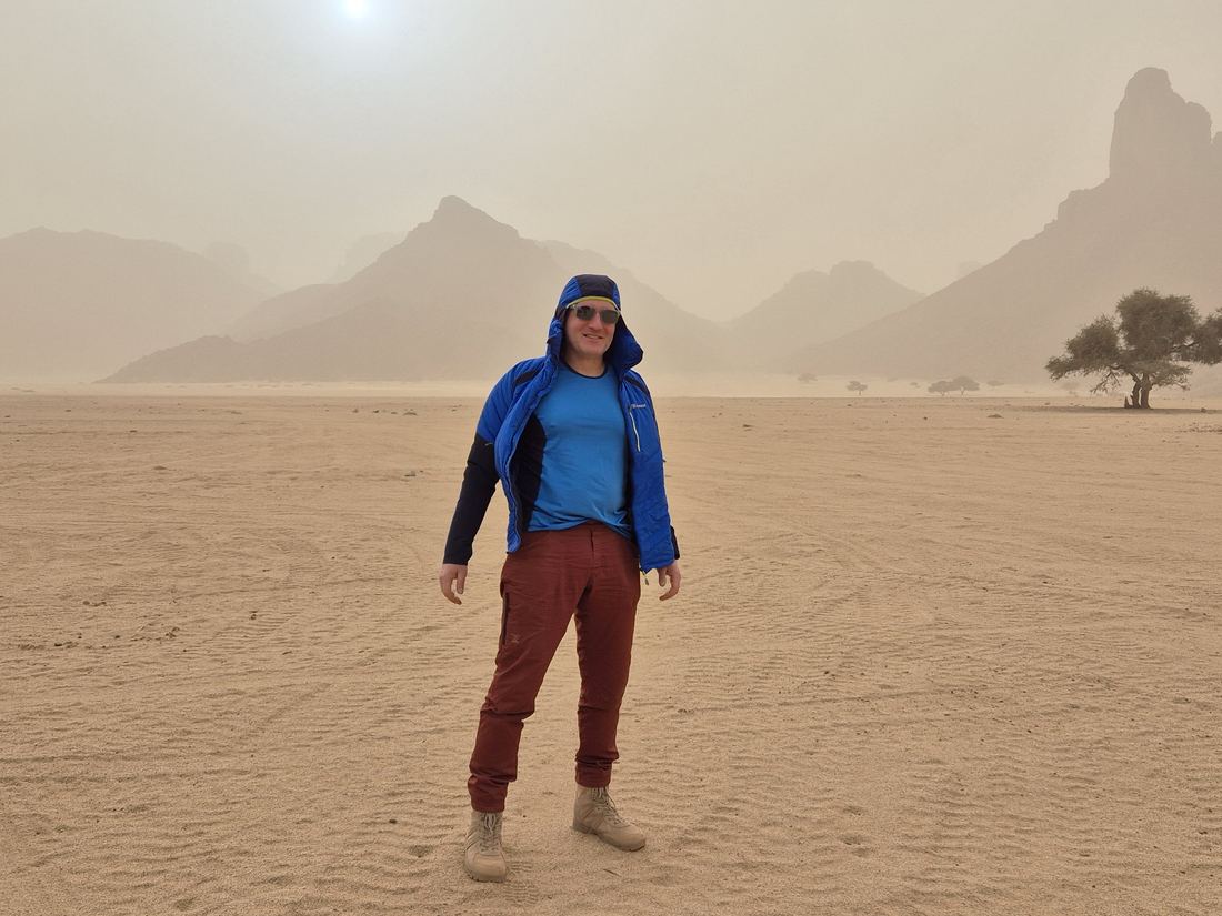 Standing in a desert under a sandstorm sky